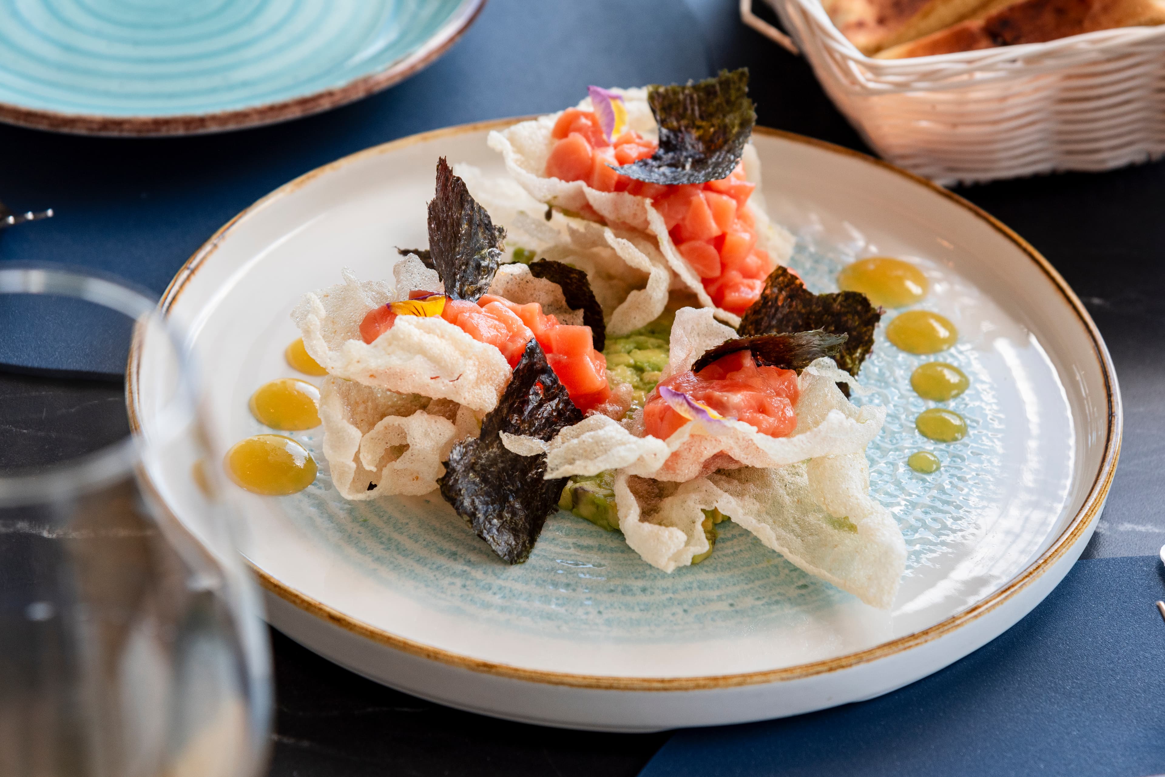 Entrante de pescado servido en un plato grande y claro.