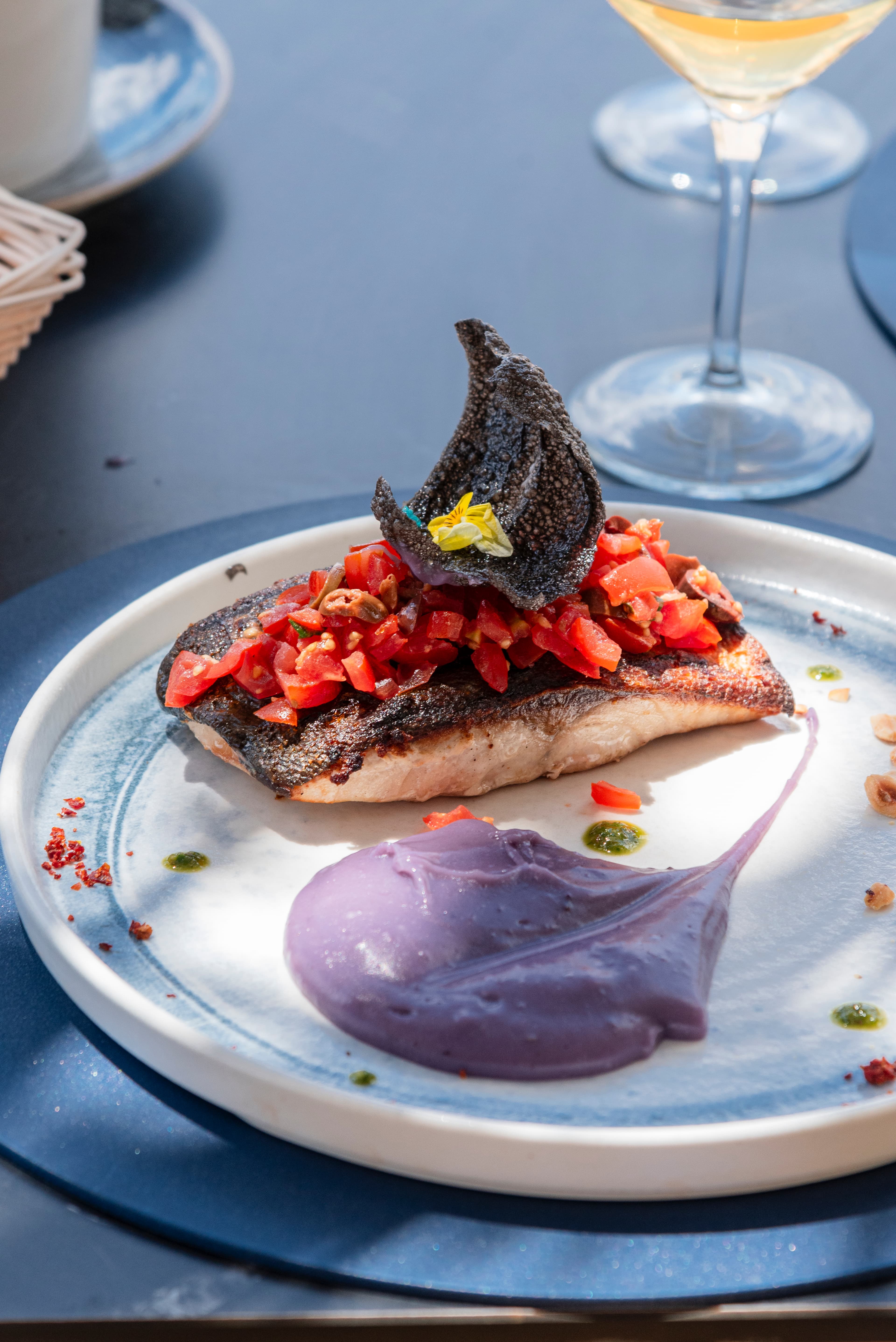 Plato de atun marcado servido con crema y verduras.